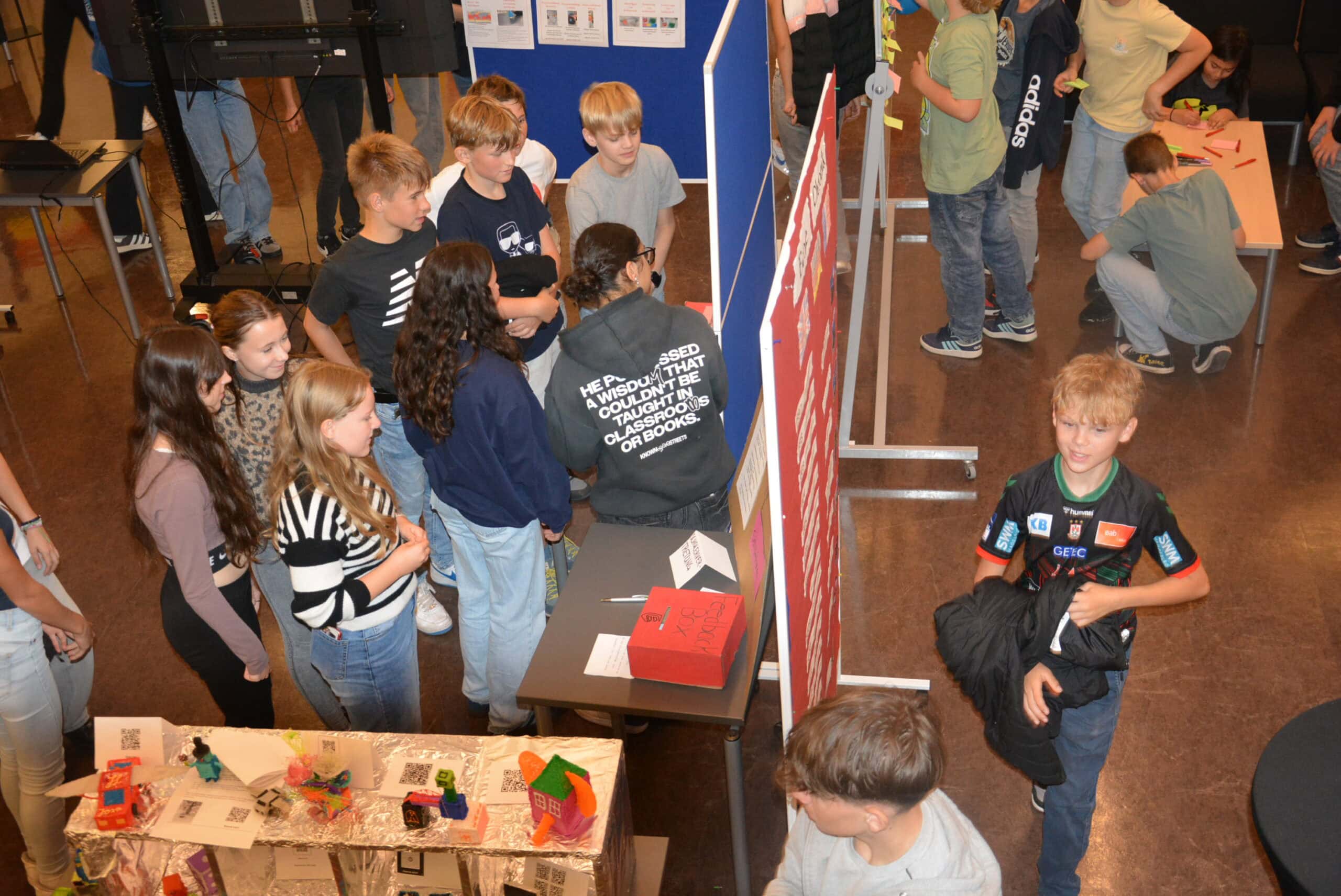 Eine Gruppe von Kindern, die in einer Ausstellung interessiert auf verschiedene Objekte schauen und diskutieren.